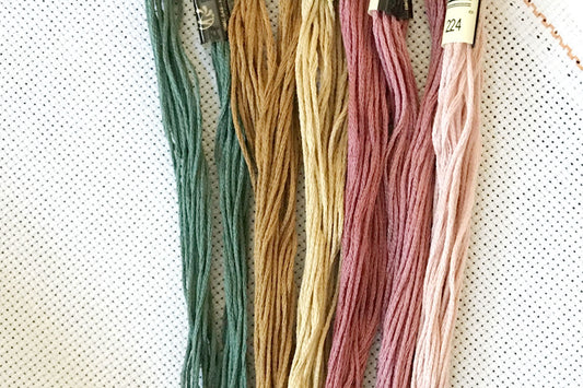 Multiple colors of threads on top of aida fabric.